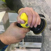 Person using a yellow AIR-830 Polisher on a granite countertop