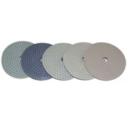 Five diamond polishing pads of different grits on a white background
