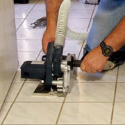 Alpha ecc-125 ecocutter with vacuum hose attached cutting a grout line