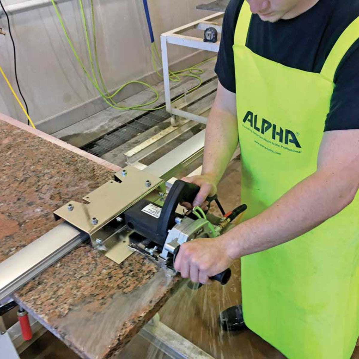 person using the alpha esc-125 5 inch stone cutter to cut granite countertop