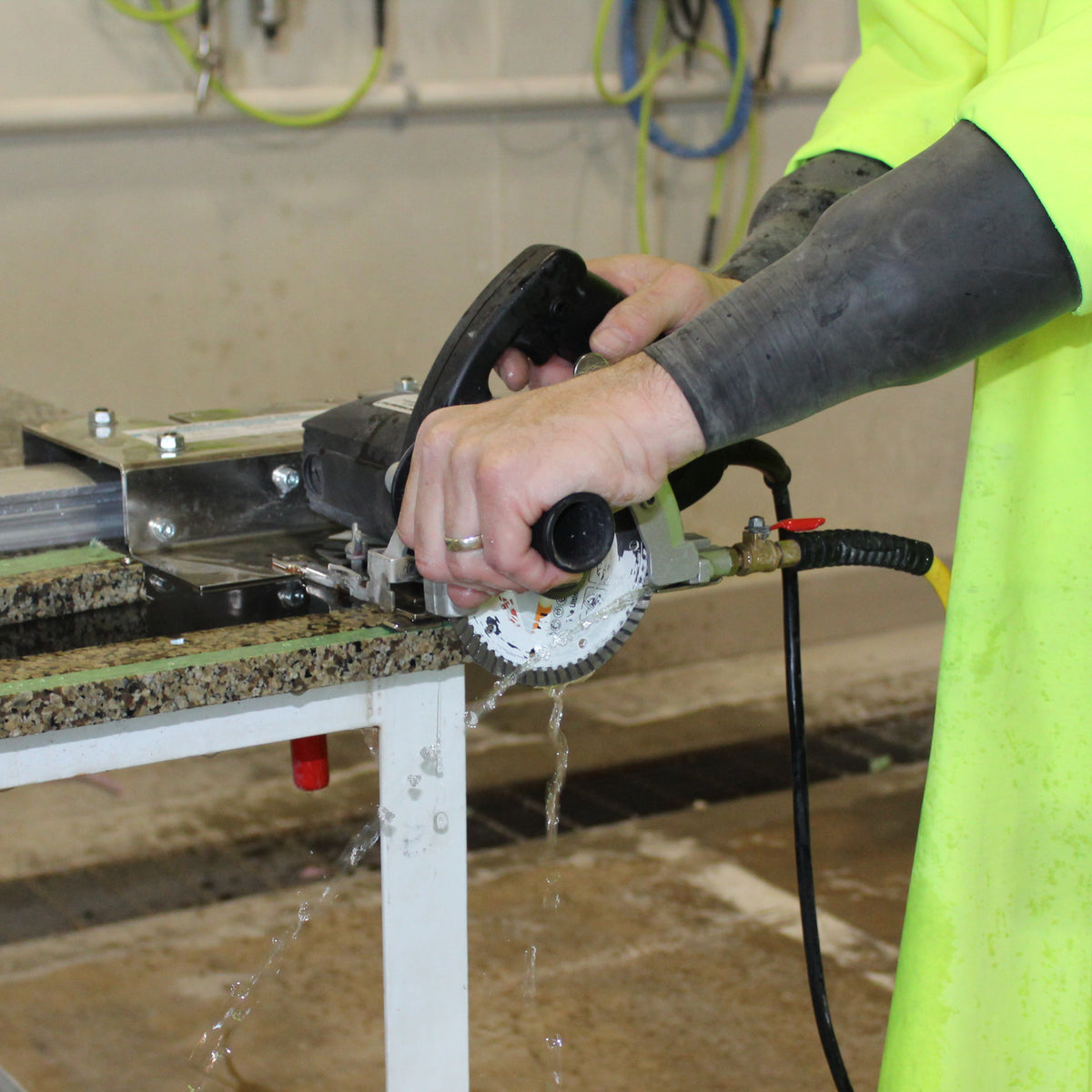person using the alpha esc-125 5 inch stone cutter to cut granite countertop