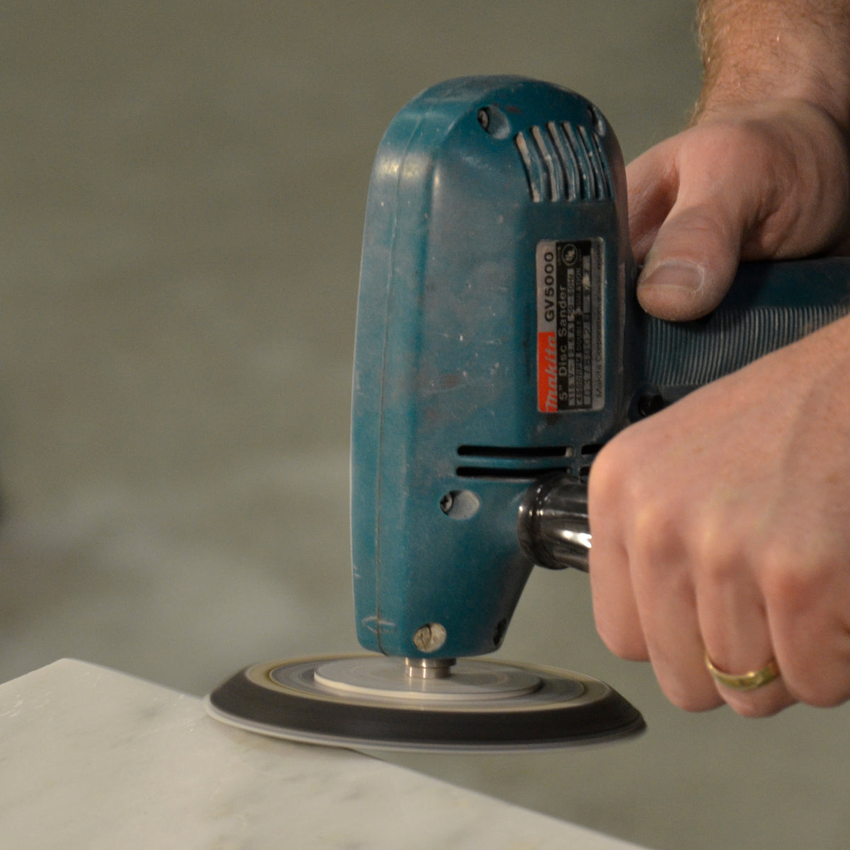 Person sanding a stone edge with Alpha sandpaper discs