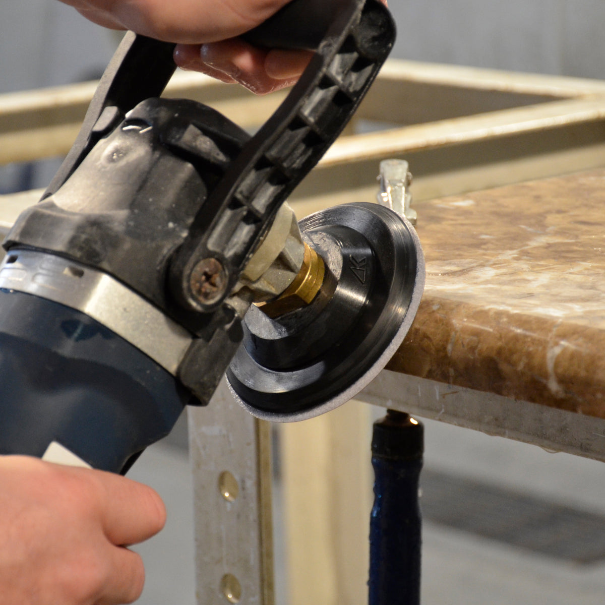 Person polishing a stone edge with  Alpha sandpaper disc