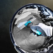 Person using the BIHUI 6.5 inch Bucket Scoop Trowel to scoop adhesive