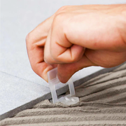 Raimondi 1/32" (1MM) Tile Leveling Clip Being Placed Under Porcelain Tile.