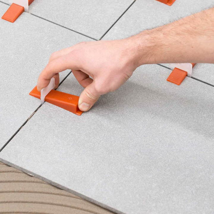 Raimondi 1/32" (1MM) Tile Leveling Clip and wedge being tightened together by hand.
